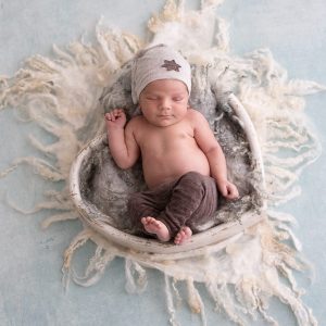 neugeborenes baby beim babyshooting in herzfoermiger holzschale