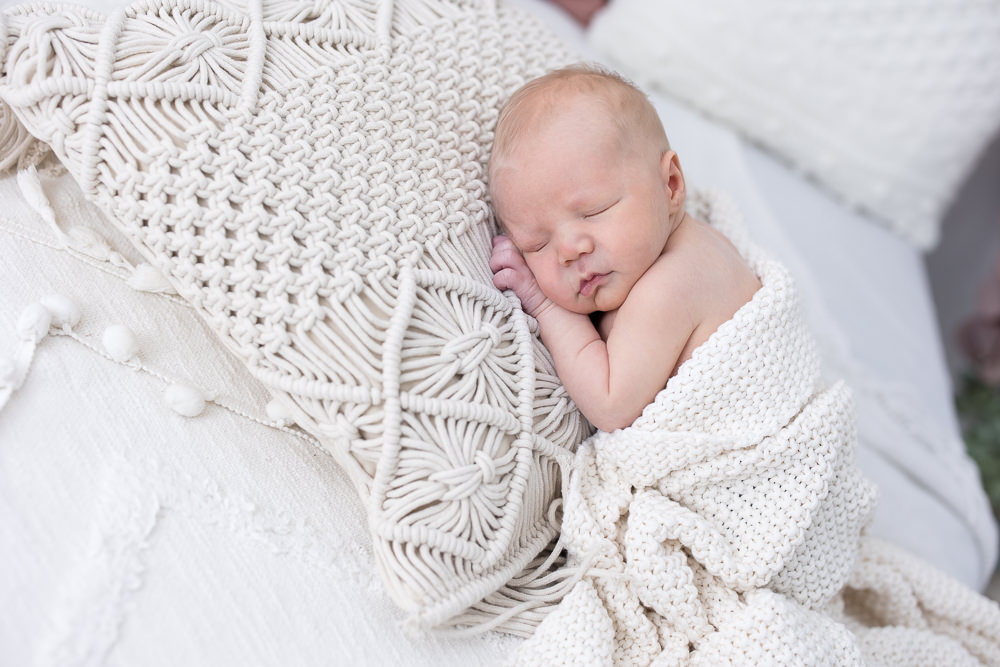 Babyfotos Wien Neugeborenes liegt auf BOHO Polster