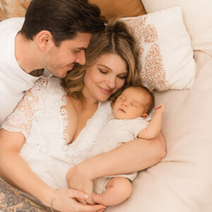 Eltern auf dem Bett mit neugeborenem Baby