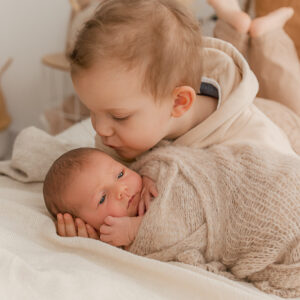 Junge küsst neugeborenes Baby