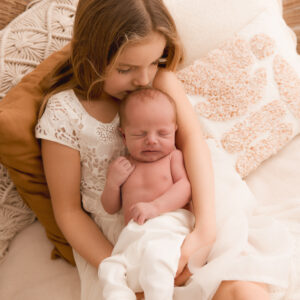Mädchen küsst neugeborenes Baby