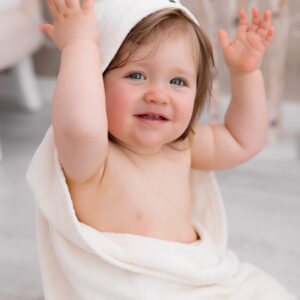 Kleines Mädchen lacht in ihrem Bademantel