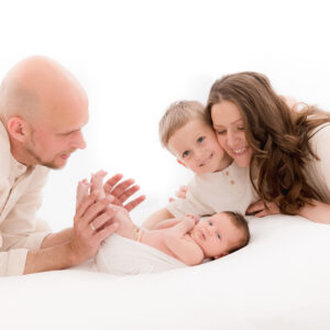 Eltern mit Kind und Neugeborenem auf weißem Hintergrund