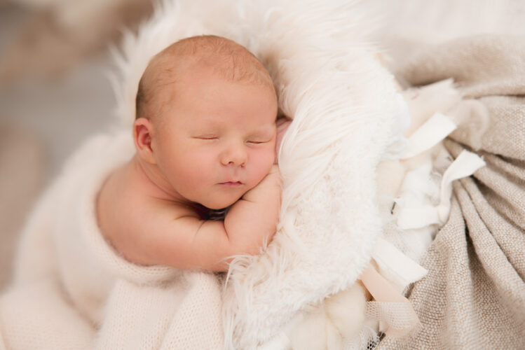 Baby schlafend auf weiß und beiger Decke