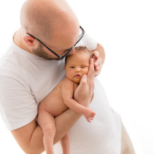 Vater hält nacktes Baby am Arm