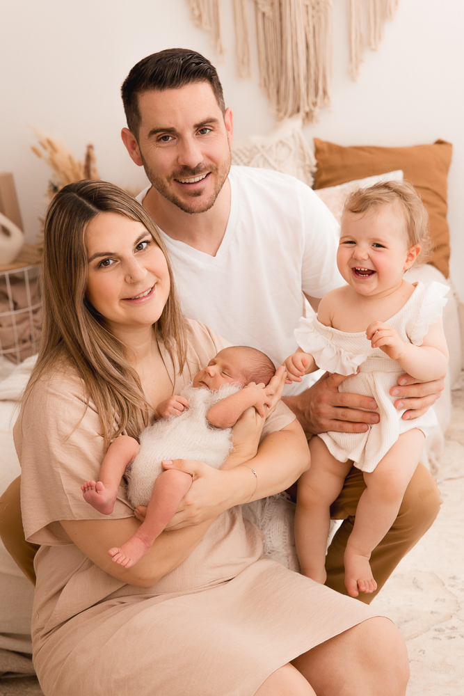 glückliche Familie sitzend Kleinkind lacht mit Baby
